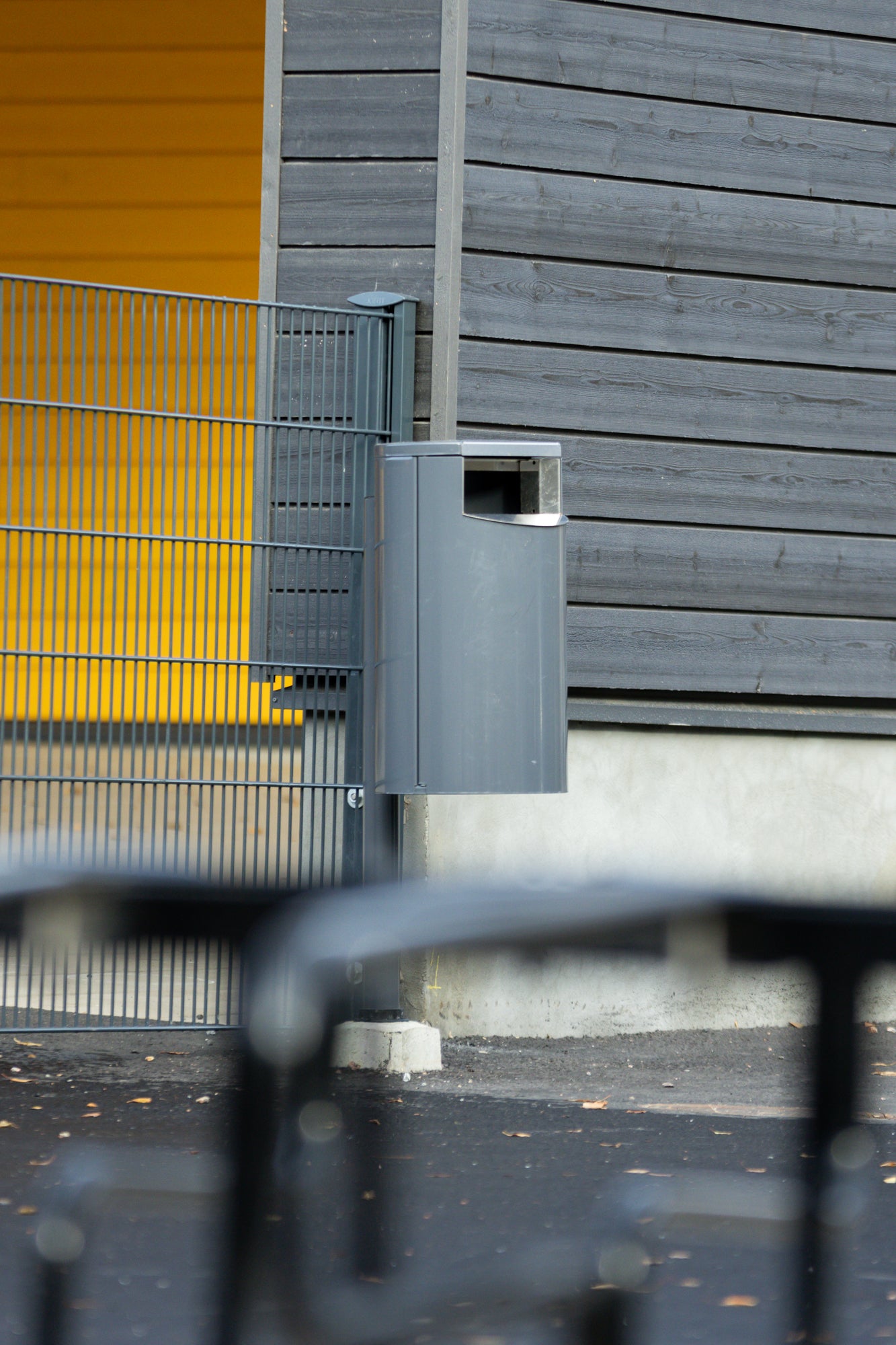 City 60 -roska-astia, tummanharmaa (RAL 7024), moderni ja kestävä roskis Ikurin päiväkodin ja koulun pihassa