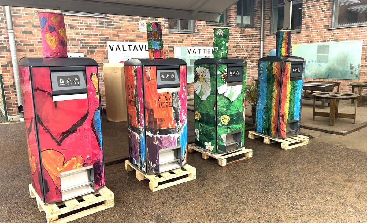 Neljä CityPack 120 -roska-astiaa lasten suunnittelemilla sydän-, kukka- ja sateenkaaritarroituksilla Göteborgin Kortedalassa.